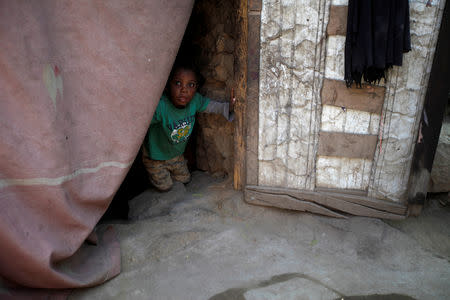 A boy displaced from the Red Sea port city of Hodeidah looks from behind a door curtain in a shelter in Sanaa, Yemen November 2, 2018. Picture taken November 2, 2018. REUTERS/Mohamed al-Sayaghi