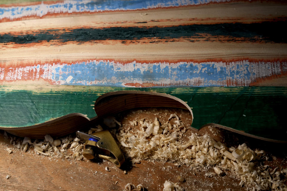 A violin made from the wood of wrecked migrants' boat is seen in the prison's lab at Milan's Opera maximum security prison, near Milan, northern Italy, Friday, Feb. 9, 2024. Inmates at Opera used the wood of wrecked boats sailed by migrants across the Sicily Channel to craft the musical instruments that the 'Sea Orchestra' used during their debut at La Scala Opera House in Milan on Monday, Feb. 12, 2024. The violins, violas and cellos played by the Orchestra of the Sea in its debut performance Monday at Milan's famed Teatro all Scala carry with them tales of hardship. (AP Photo/Antonio Calanni)