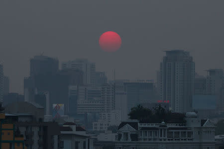 FILE PHOTO: The sun is seen through evening air pollution in Bangkok, Thailand February 8, 2018. REUTERS/Athit Perawongmetha/File Photo
