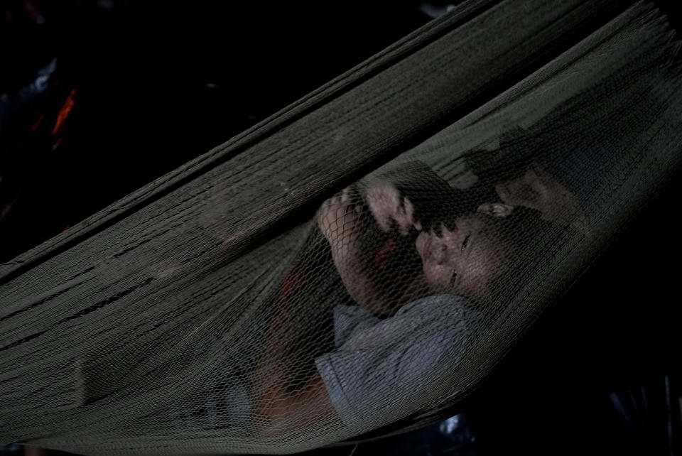 Venezuela migrants rest on a hammock for the night as they wait for a boat to take them to Acandi, from in Necocli, Colombia, Thursday, Oct. 13, 2022. The U.S. announced on Oct. 12, that Venezuelans who walk or swim across the border will be immediately returned to Mexico without rights to seek asylum. (AP Photo/Fernando Vergara)