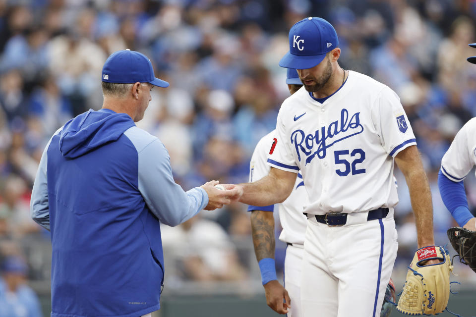 Kansas City Royals starting pitcher Michael Wacha (52) hands the ball to manager Matt Quatraro, left, as he is taken out of the baseball game during the fourth inning against the Texas Rangers in Kansas City, Mo., Saturday, May 4, 2024. (AP Photo/Colin E. Braley)