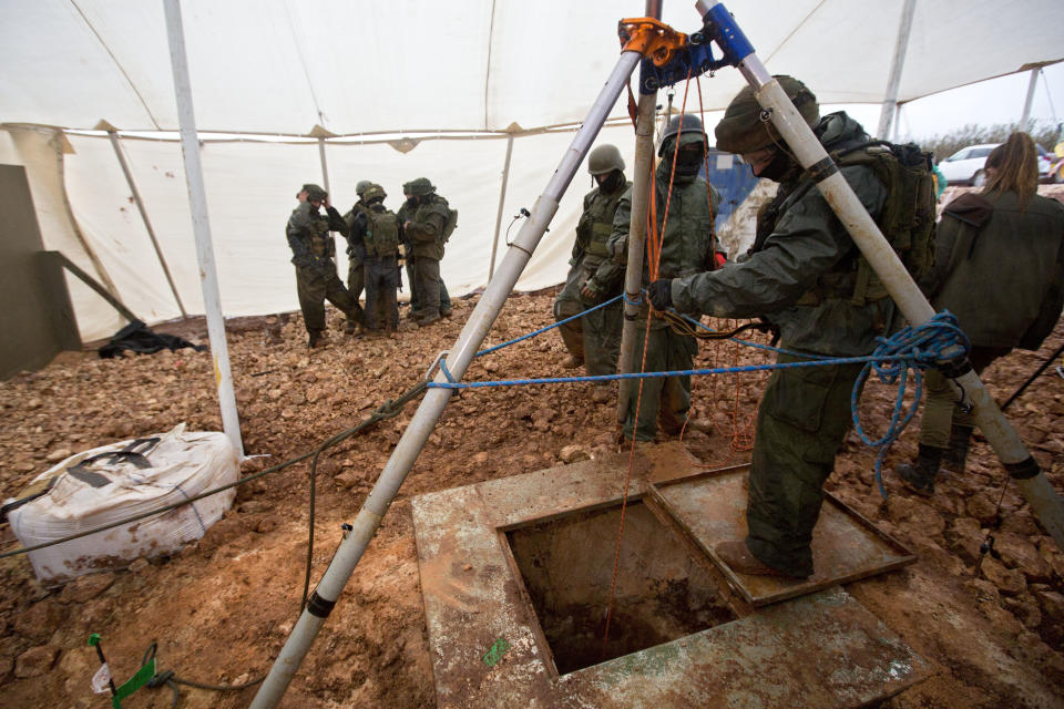 File - In this Wednesday, Dec. 19, 2018 file photo, Israeli soldiers stand around the opening of a hole that leads to a tunnel that the army says crosses from Lebanon to Israel, near Metula. The Israel military says it has concluded "Operation Northern Shield" by uncovering the sixth and final Hezbollah attack tunnel from Lebanon. (AP Photo/Sebastian Scheiner, File)