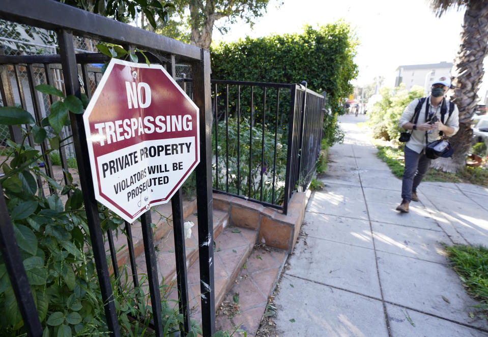 A No Trespassing sign appears on a gate near an area on North Sierra Bonita Ave. where Lady Gaga's dog walker was shot and two of her French bulldogs stolen, Thursday, Feb. 25, 2021, in Los Angeles. The dog walker was shot once Wednesday night and is expected to survive his injuries. The man was walking three of Lady Gaga's dogs at the time but one escaped. (AP Photo/Chris Pizzello)