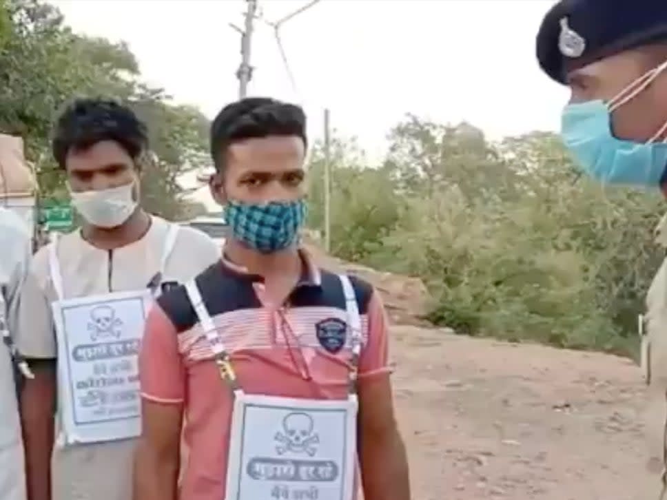 A screenshot of the video shows two men standing with a pamphlet pasted on their shirts that says ‘stay away from me’ (Screengrab/Video )