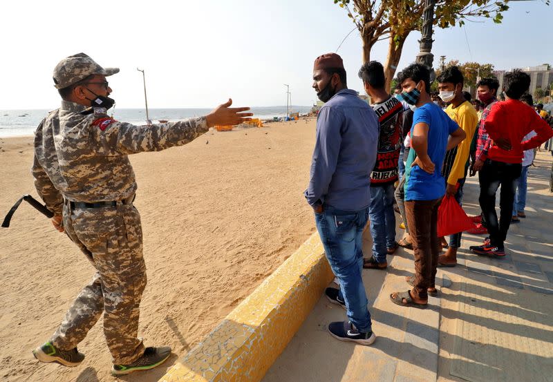 A policeman asks people to leave Juhu beach to prevent public gatherings during Holi festival in Mumbai