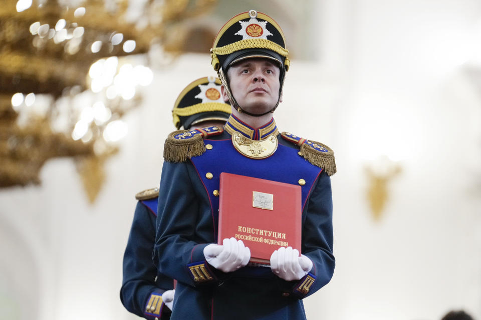 A Honour guard soldier carries the Russian Constitution during Vladimir Putin's inauguration ceremony as Russian president in the Grand Kremlin Palace in Moscow, Russia, Tuesday, May 7, 2024. (AP Photo/Alexander Zemlianichenko, Pool)