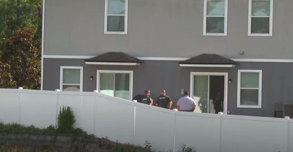 St. Johns County Sheriff's Office investigators gather behind Jose Melendez's home on Servia Drive after his body was discovered there.