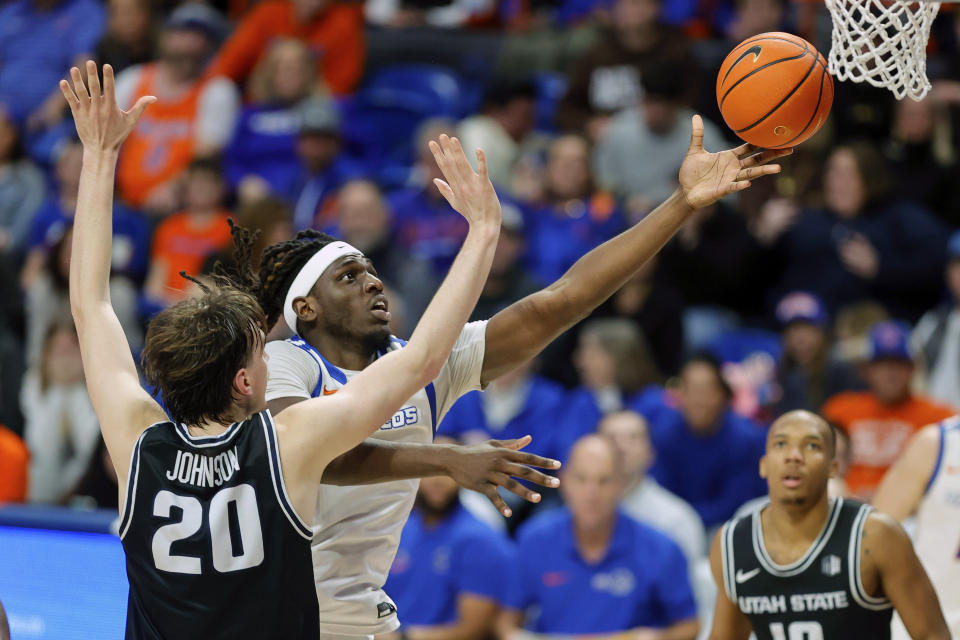 Boise State forward O'Mar Stanley (1) gores to the basket paste the defense of Utah State center Isaac Johnson (20) second half of an NCAA college basketball game, Saturday, Jan. 27, 2024, in Boise, Idaho. Utah State won 90-84. (AP Photo/Steve Conner)