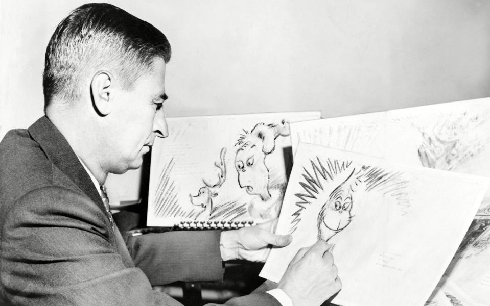 Dr. Seuss at work on a drawing of the Grinch, a character in his book, How the Grinch Stole Christmas. 1957 - Shutterstock