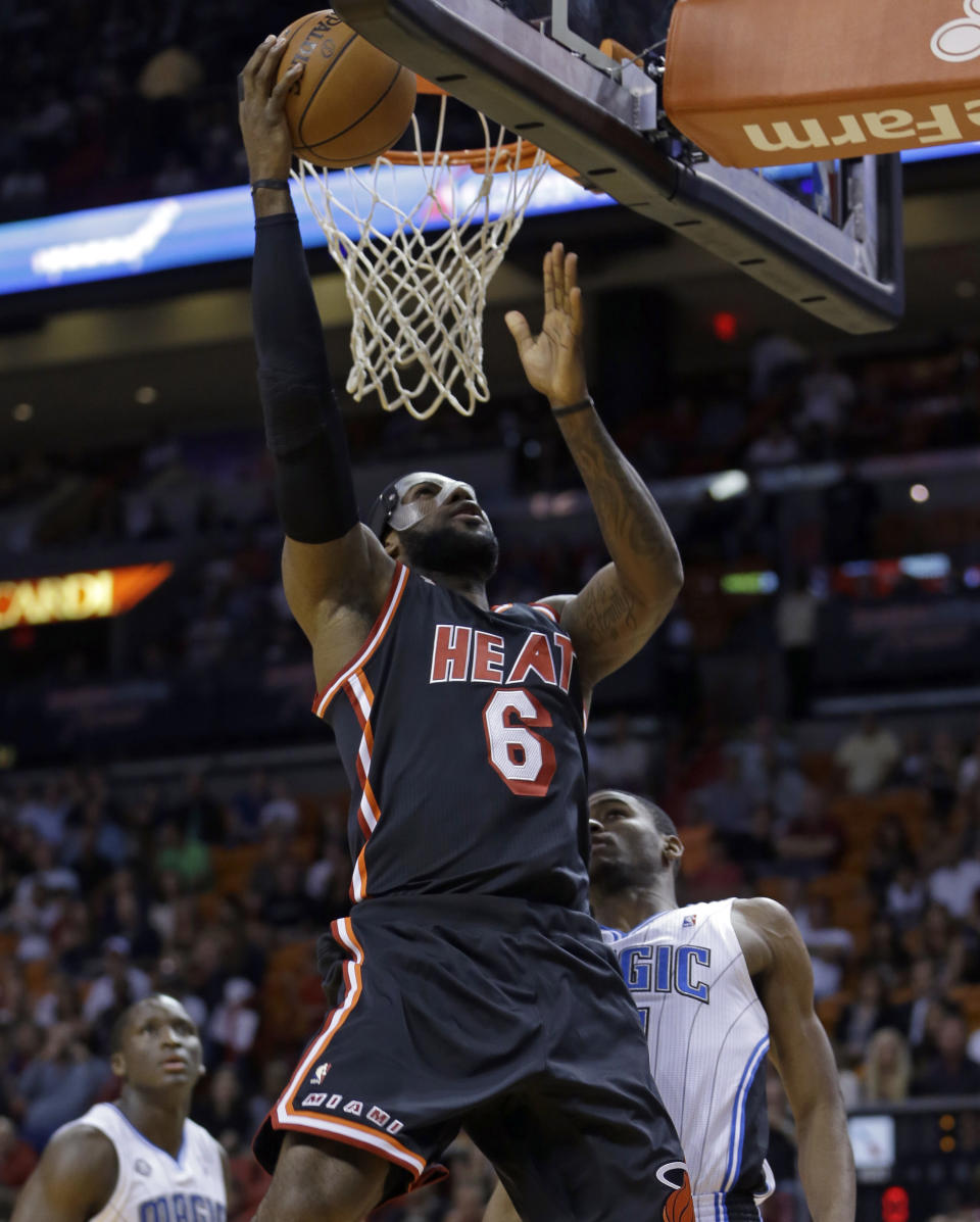 Miami Heat small forward LeBron James (6) goes to the basket against Orlando Magic small forward Maurice Harkless during the first half of an NBA basketball game in Miami, Saturday, March 1, 2014. (AP Photo/Alan Diaz)
