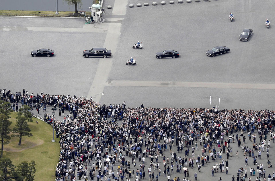 In this aerial photo, the motorcade of Japan's new Emperor Naruhito, second from left, move past well-wishers after attending his imperial rituals at the Imperial Palace Wednesday, May 1, 2019, in Tokyo. Emperor Naruhito inherited Imperial regalia and seals as proof of his succession and pledged in his first public address Wednesday to follow his father's example in devoting himself to peace and staying close to the people. (Takuya Inaba/Kyodo News via AP)