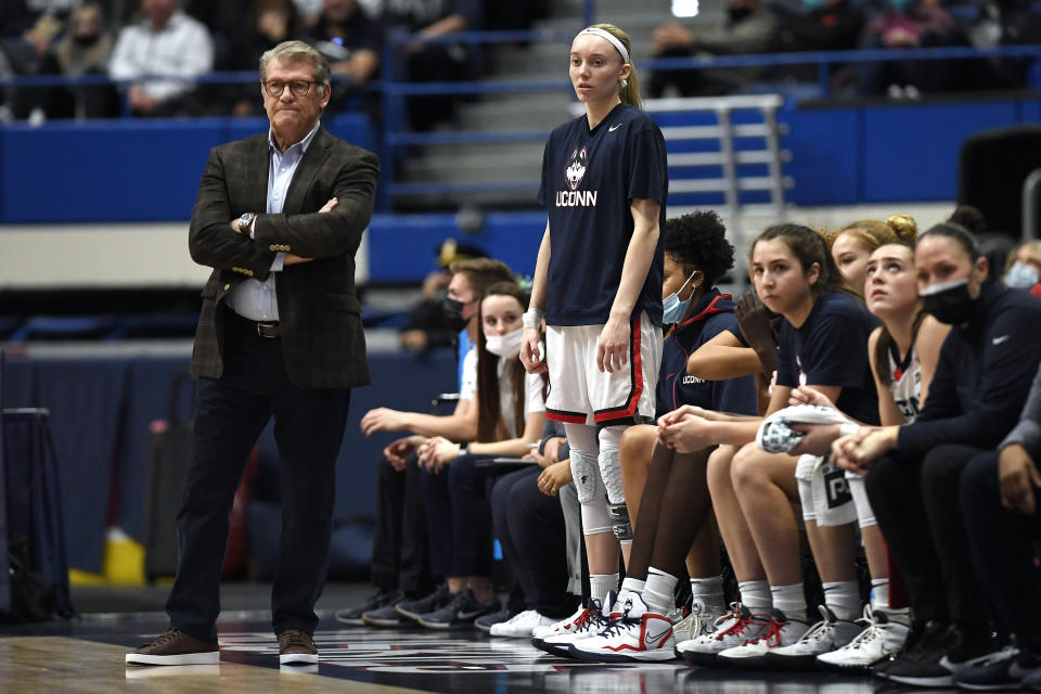 Connecticut coach Geno Auriemma and player Paige Bueckers watch during the first half of the team's NCAA college basketball game against Marquette, Wednesday, Feb. 23, 2022, in Hartford, Conn. (AP Photo/Jessica Hill)