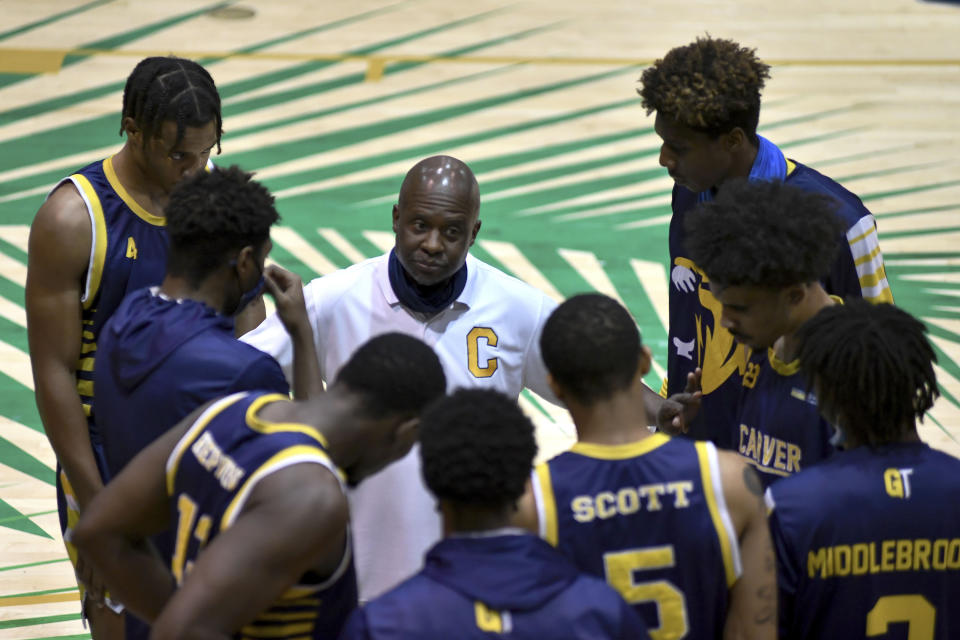 Bryan Spencer, center, head coach of the Carver College talks with his players before their game against Florida International Monday, Dec. 21, 2020, in Miami. (AP Photo/Gaston De Cardenas)