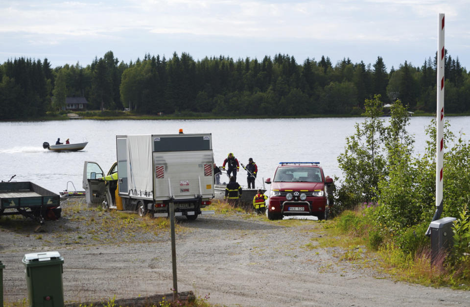 Emergency services attend the accident site at a small harbor at Ume river, outside Umea, Sweden, Sunday July 14, 2019. Swedish officials say a small plane carrying parachutists crashed in northern Sweden and all nine of the people on board were killed. (Samuel Pettersson/TT via AP)