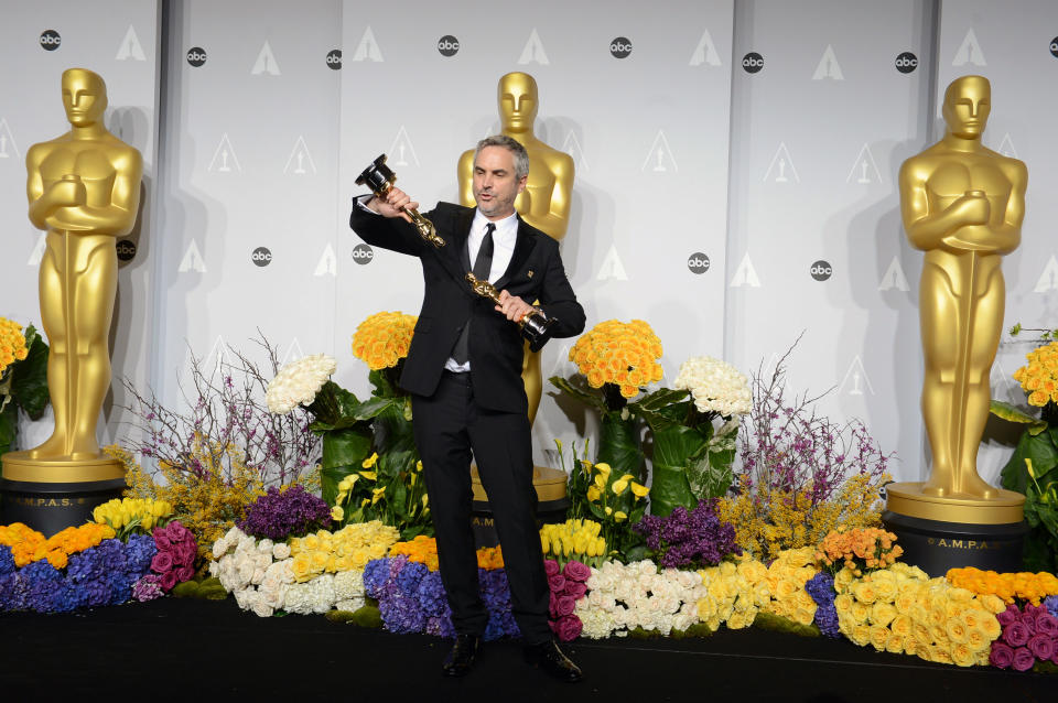 Alfonso Cuaron poses in the press room with his awards for best film editing and best director for "Gravity" during the Oscars at the Dolby Theatre on Sunday, March 2, 2014, in Los Angeles. (Photo by Jordan Strauss/Invision/AP)