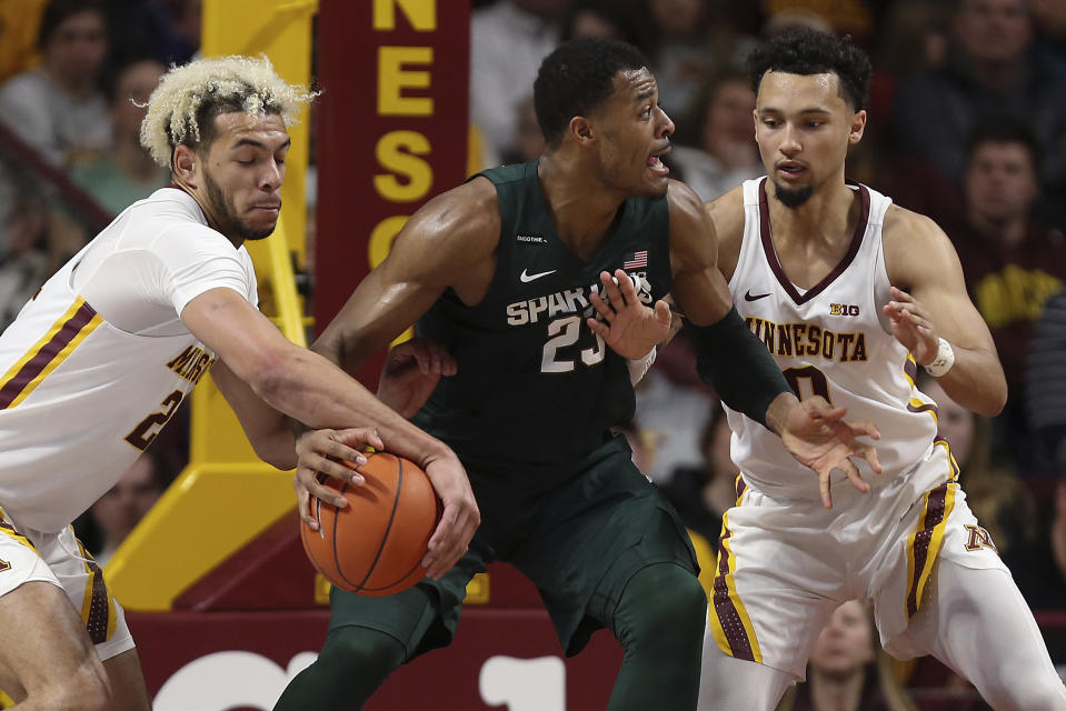 Minnesota's Jarvis Omersa, left, steals the ball from Michigan State's Xavier Tillman during an NCAA college basketball game Sunday, Jan. 26, 2020, in Minneapolis. (AP Photo/Stacy Bengs)