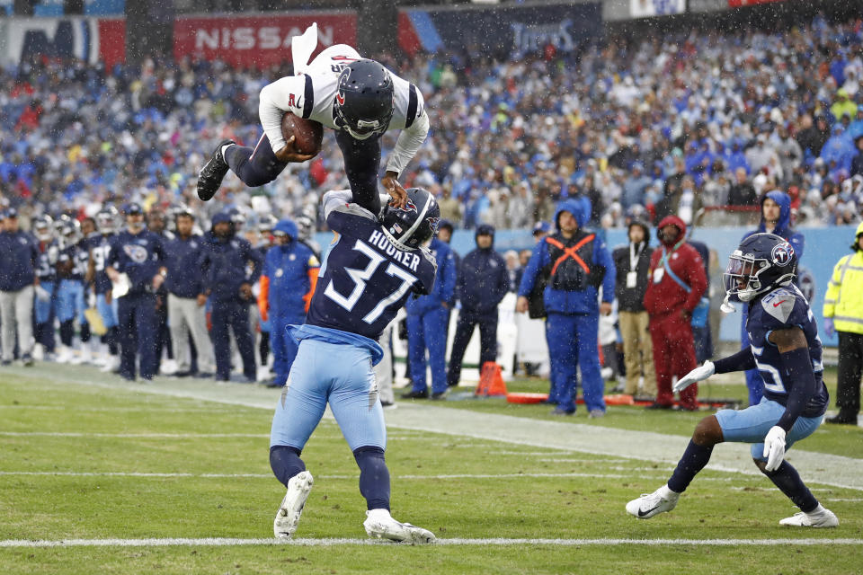 Houston Texans quarterback Tyrod Taylor, top, leaps over Tennessee Titans safety Amani Hooker (37) for a touchdown in the first half of an NFL football game Sunday, Nov. 21, 2021, in Nashville, Tenn. (AP Photo/Wade Payne)