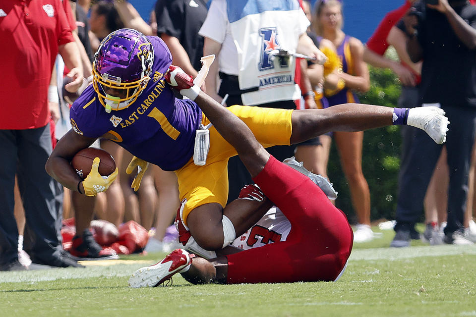 East Carolina's Jaylen Johnson (1) stretches for extra yards in the grasp of North Carolina State's Aydan White (3) during the first half of an NCAA college football game in Greenville, N.C., Saturday, Sept. 3, 2022. (AP Photo/Karl B DeBlaker)