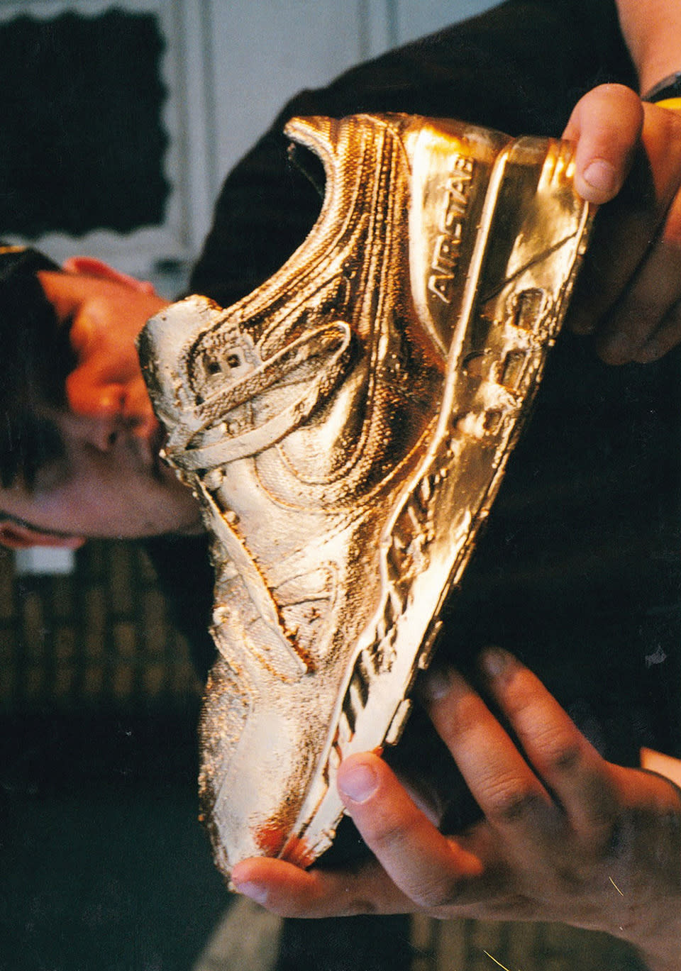 Tommy Rebel holding a 24 karat gold-plated Air Stab sneaker.