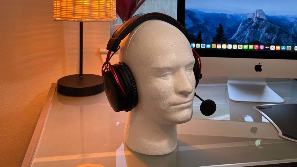 A HyperX Cloud Alpha Wireless gaming headset on a glass desk