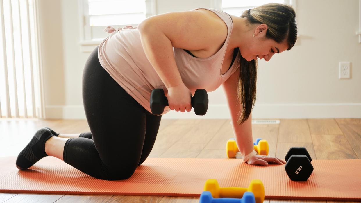  Woman doing a dumbbell workout at home 