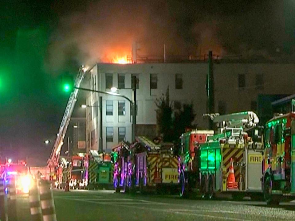 Fire engines gather outside the Loafers Lodge hostel in Wellington, New Zealand on Tuesday 16 May 2023 (NewsHub via AP)