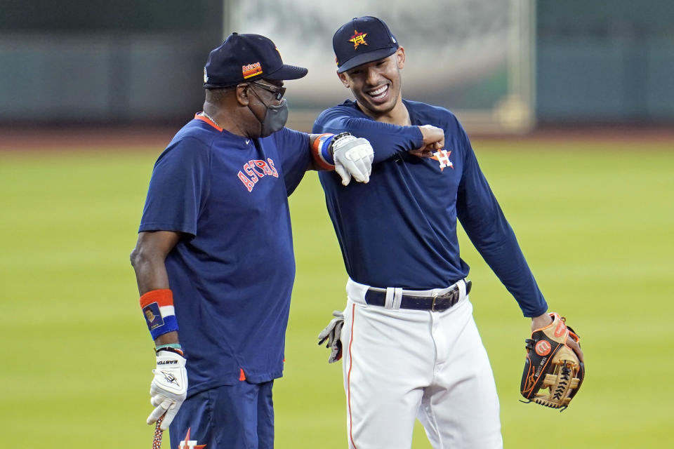 Houston Astros' Carlos Correa, right, bumps elbows with manager Dusty Baker during a baseball practice at Minute Maid Park, Saturday, July 4, 2020, in Houston. (AP Photo/David J. Phillip)