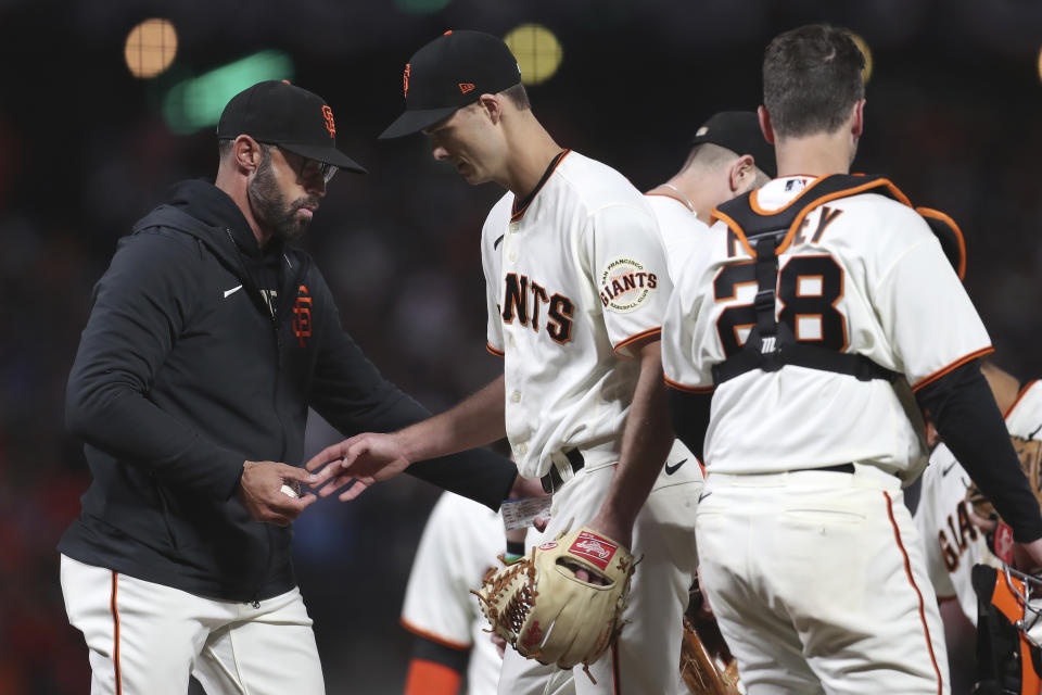 San Francisco Giants pitcher Tyler Rogers, middle, hands the ball to manager Gabe Kapler during the eighth inning of Game 5 of a baseball National League Division Series against the Los Angeles Dodgers Thursday, Oct. 14, 2021, in San Francisco. (AP Photo/Jed Jacobsohn)