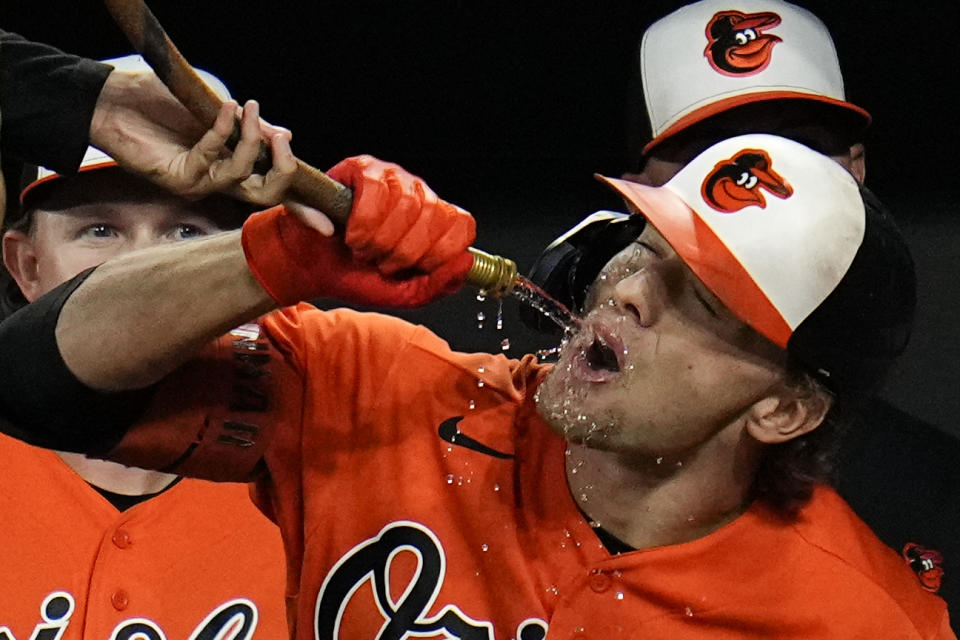 Baltimore Orioles' Gunnar Henderson drinks from the "Homer Hose" after hitting a two-run home run to score Adam Frazier in the second inning of a baseball game against the Tampa Bay Rays, Saturday, Sept. 16, 2023, in Baltimore. (AP Photo/Julio Cortez)