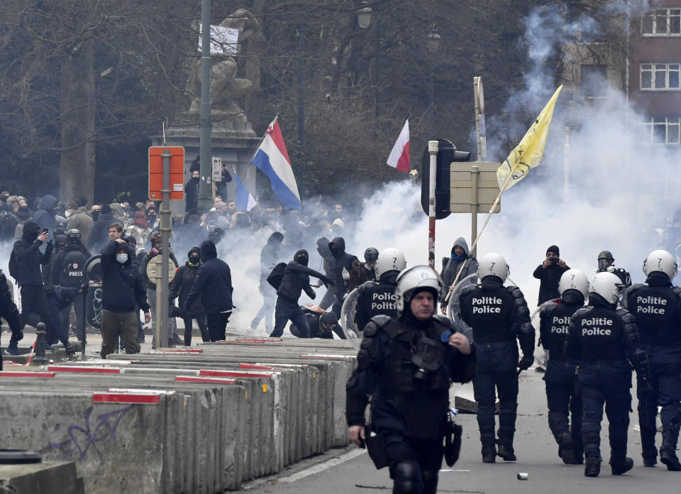 Police confront protestors during a demonstration against COVID-19 measures in Brussels, Sunday, Jan. 23, 2022. Demonstrators gathered in the Belgian capital to protest what they regard as overly extreme measures by the government to fight the COVID-19 pandemic, including a vaccine pass regulating access to certain places and activities and possible compulsory vaccines. (AP Photo/Geert Vanden Wijngaert)