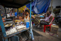 A street vendor prepares food as a man eats in a wholesale vegetable market in Guwahati, India, Wednesday, Feb. 1, 2023. Indian Prime Minister Narendra Modi's government ramped up capital spending by a substantial 33% to $122 billion in an annual budget presented to Parliament on Wednesday, seeking to spur economic growth and create jobs ahead of a general election next year. (AP Photo/Anupam Nath)