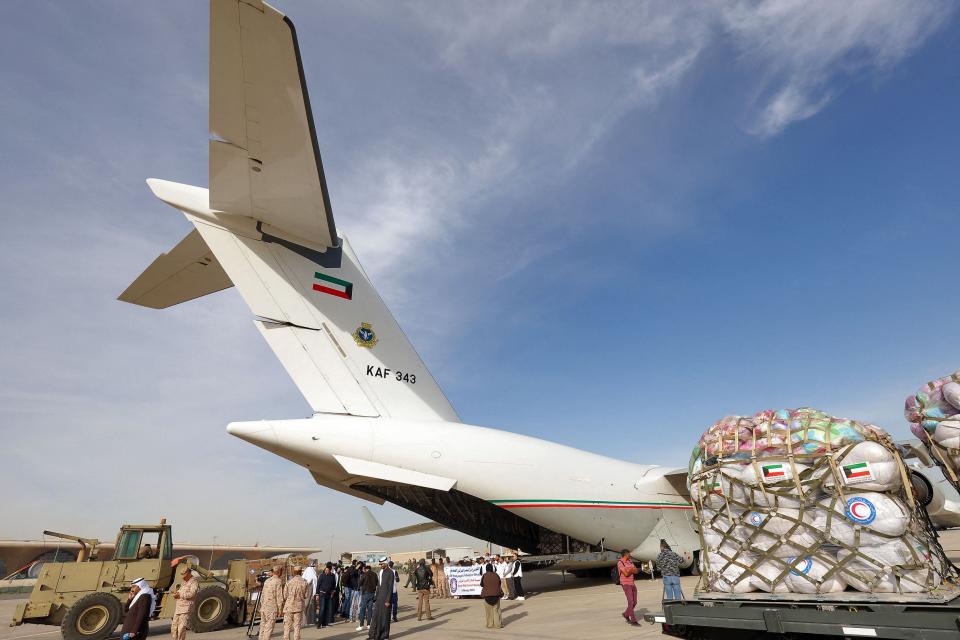 Kuwaiti army soldiers load a military plane with humanitarian aid for Turkey following a deadly earthquake (AFP via Getty Images)