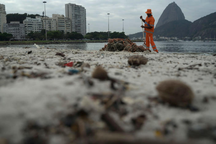 <p>A clean workers removes the trash over the sand of Botafogo beach next to the Sugar Loaf mountain and the Guanabara Bay in Rio de Janeiro, Brazil, Saturday, July 30, 2016. Just days ahead of the Olympic Games the waterways of Rio de Janeiro are as filthy as ever, contaminated with raw human sewage teeming with dangerous viruses and bacteria, according to a 16-month-long study commissioned by The Associated Press.(AP Photo/Leo Correa)