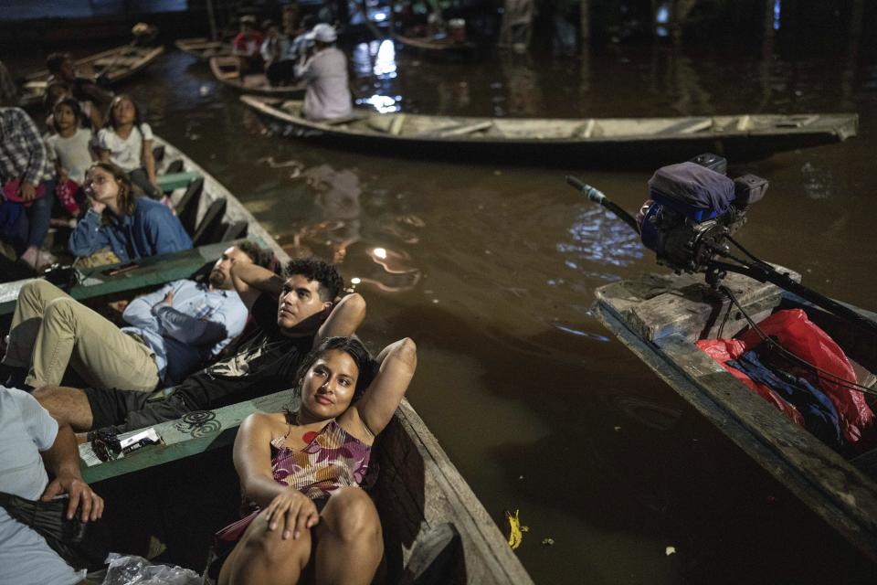 Spectators watch from boats a film projected on a screen set up on a wooden structure during the Muyuna Floating Film Festival, that celebrares tropical forests, in the Belen neighborhood of Iquitos, Peru, Saturday, May 25, 2024. (AP Photo/Rodrigo Abd)