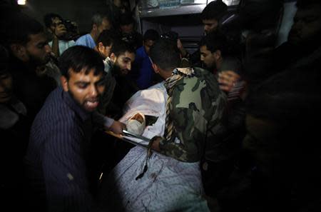 Palestinians react as they gather around the body of a Hamas militant at a hospital in Khan Younis in the southern Gaza Strip October 31, 2013. REUTERS/Ibraheem Abu Mustafa