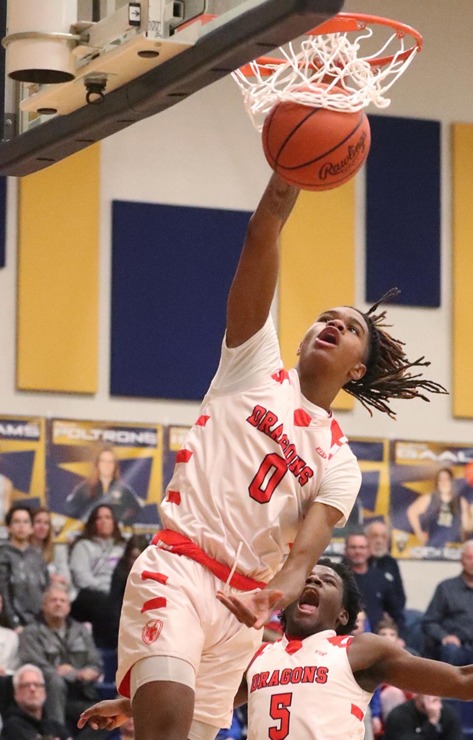 East's De'Arion Holley dunks as teammate Kardlay Tyler reacts during the Div. II district semifinal boys basketball game against Revere at North Ridgeville Academic Center on Thursday.