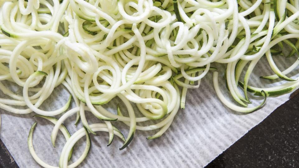 close up of fresh zucchini noodles in baking pan