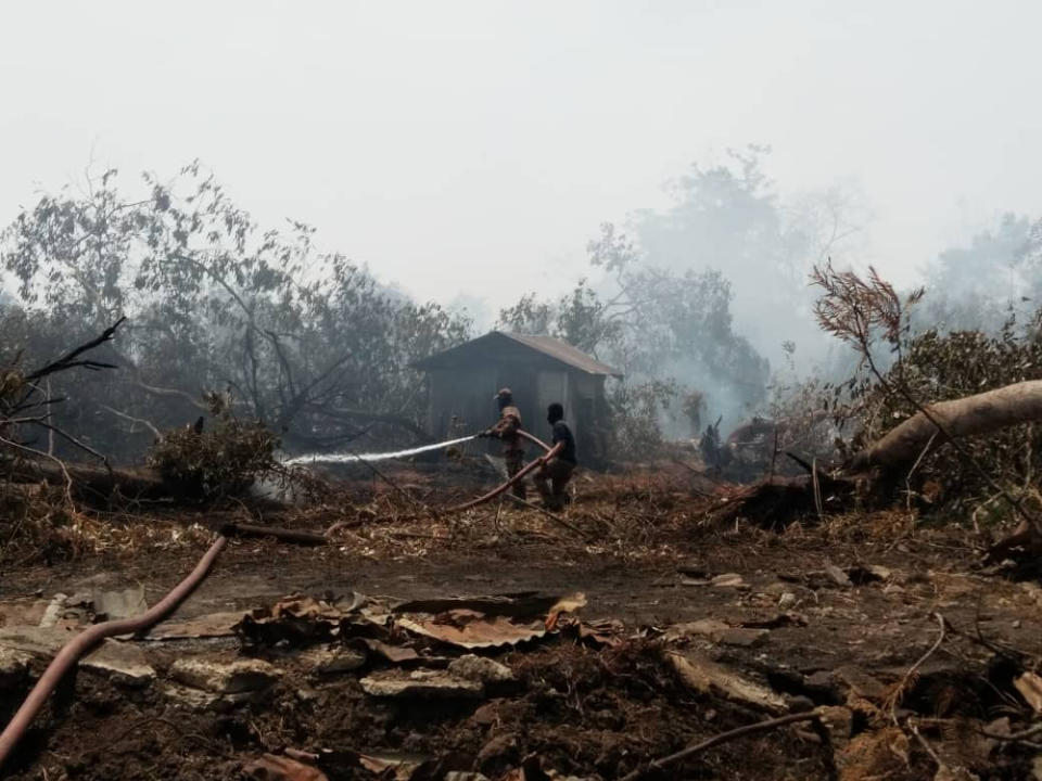 Firemen containing the secondary forest fire at Jalan Tanjung Kupang in Kampung Pekajang, Gelang Patah today. — Picture courtesy of the Johor Fire and Rescue Department