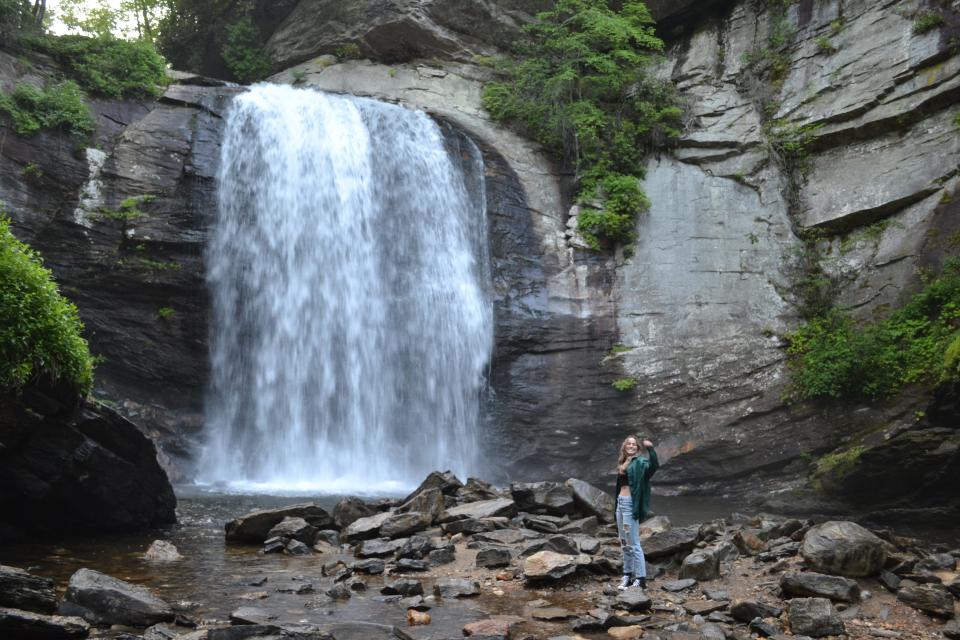 Get Outside WNC founder Jenna Watson takes a photo at Looking Glass Falls in Pisgah National Forest near Brevard. Get Outside WNC offers guided social hikes for all ages and abilities to encourage a love for the outdoors and teach the importance of conservation.