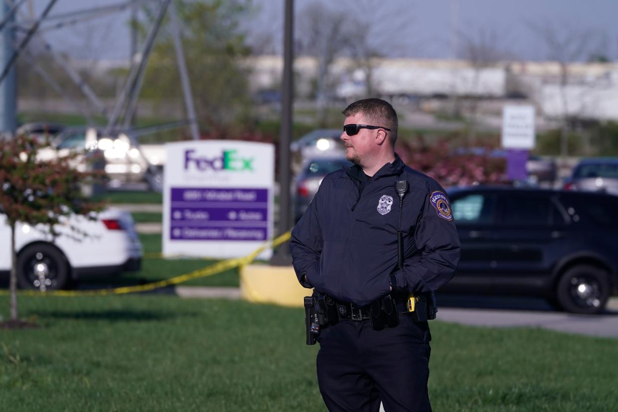 A Police officer stands near the scene where multiple people were shot at the FedEx Ground facility early Friday morning, April 16, 2021, in Indianapolis.