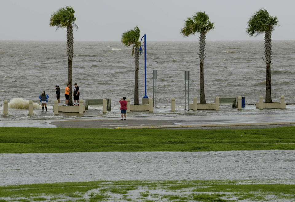 People check out the waves on Lakeshore Drive in New Orleans, Friday, July 12, 2019, as water moves in from Lake Pontchartrain from the storm surge from Tropical Storm Barry in the Gulf of Mexico. The area is behind a levee that protects the rest of the city. Barry could harm the Gulf Coast environment in a number of ways. But scientists say it’s hard to predict how severe the damage will be. (AP Photo/Matthew Hinton)