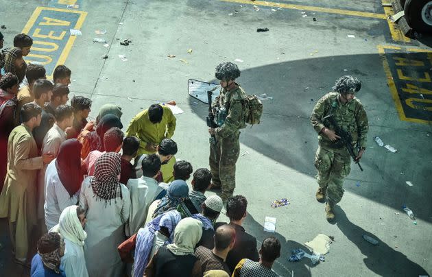 US soldiers stand guard as Afghan people wait at the Kabul airport in Kabul on August 16, 2021 (Photo: WAKIL KOHSAR via Getty Images)