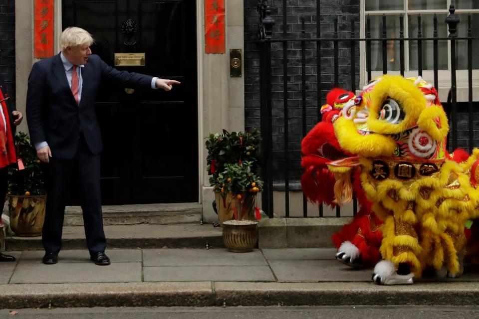 British Prime Minister Boris Johnson points at performers dressed as lions as he welcomes members of the British Chinese community for Chinese New Year (AP)