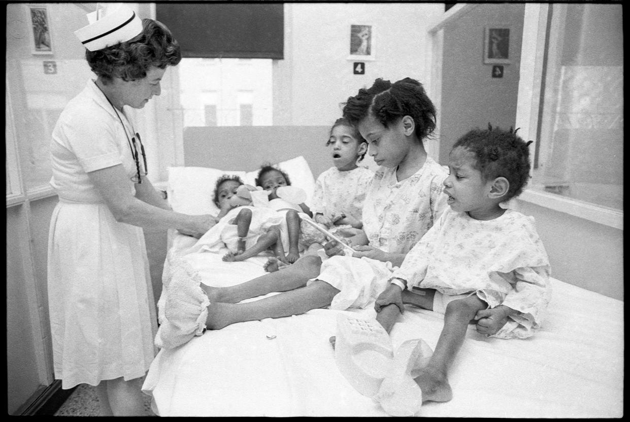 Nurse, Ann McQuain, left, provides some food and some attention  to the surviving Ellis children. Their brother died Thanksgiving Eve of malnutrition, in Louisville, Kentucky. The children were identified, left to right, Sandra, 15 months, Marie, about 3, Betty, 8, Mary, 11 and Victoria, 3 or 4, on right. Nov. 27, 1969