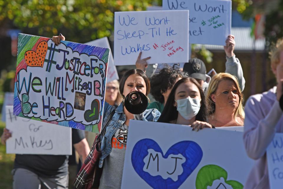 Friends and family of Michael "Mikey" Benedict march in front of Just Jokin' in Crestline on Oct. 19, chanting "Justice for Mikey."