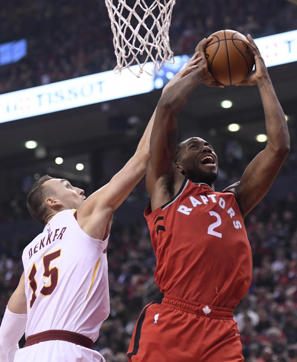 Toronto Raptors forward Kawhi Leonard (2) is stopped by Cleveland Cavaliers forward Sam Dekker (15) during the first half of an NBA basketball game, Wednesday, Oct. 17, 2018, in Toronto. (Nathan Denette/The Canadian Press via AP)