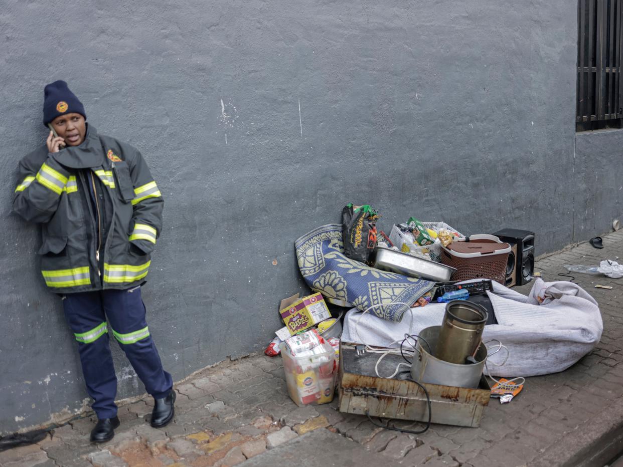 A member of the emergency services stands next to belongings of people evacuated out of a building (AFP via Getty Images)