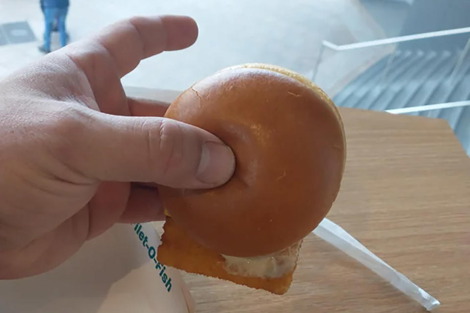 Man holding McDonald's Filet-O-Fish burger