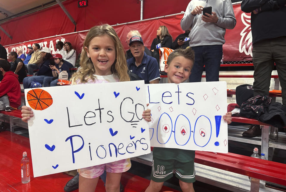 Tessa Kowitz, left, and Jackson Kowitz root for Antelope Valley during the team's game against Huntingdon (Ind.) in the first round of the NAIA men's basketball tournament Friday, March 15, 2024, in Glendale, Ariz. They are the niece and nephew of coach Jordan Mast. The private university in Lancaster, Calif., announced it was closing on March 6 because of financial difficulties. Antelope Valley lost to Huntington (Indiana). (AP Photo/David Brandt)