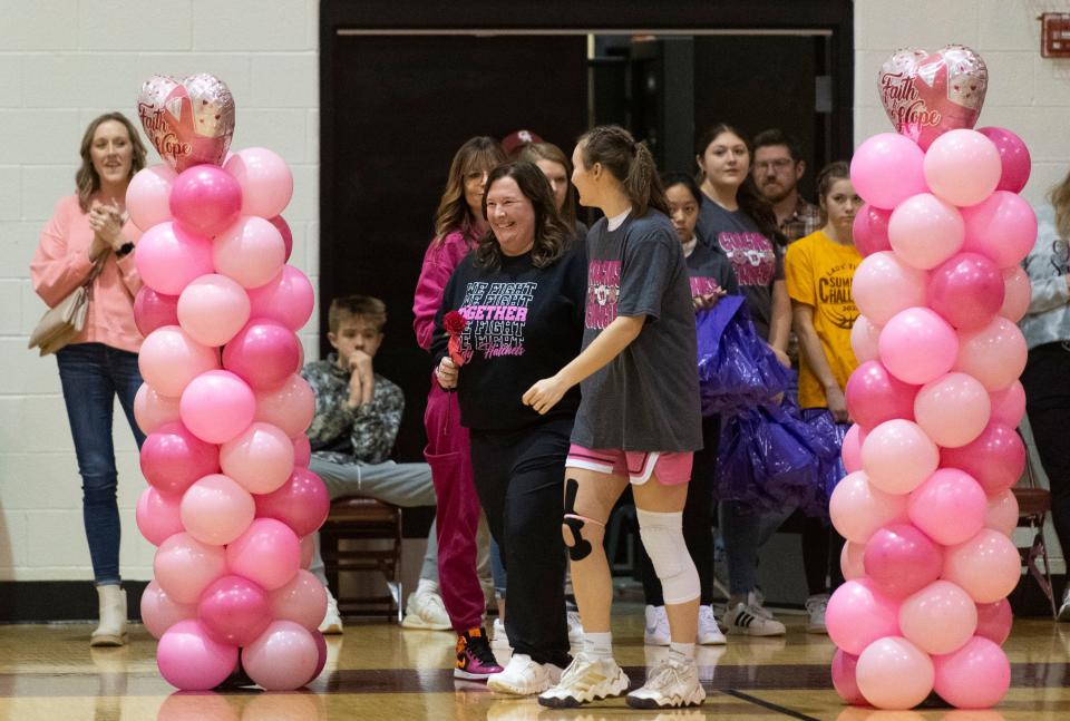 Washington Head Coach Gretchen Miles walks out with Gibson Southern’s Chloey Graham (41) as she is recognized ahead of the coaches vs cancer game at Gibson Southern High School Saturday, Jan. 13, 2024.